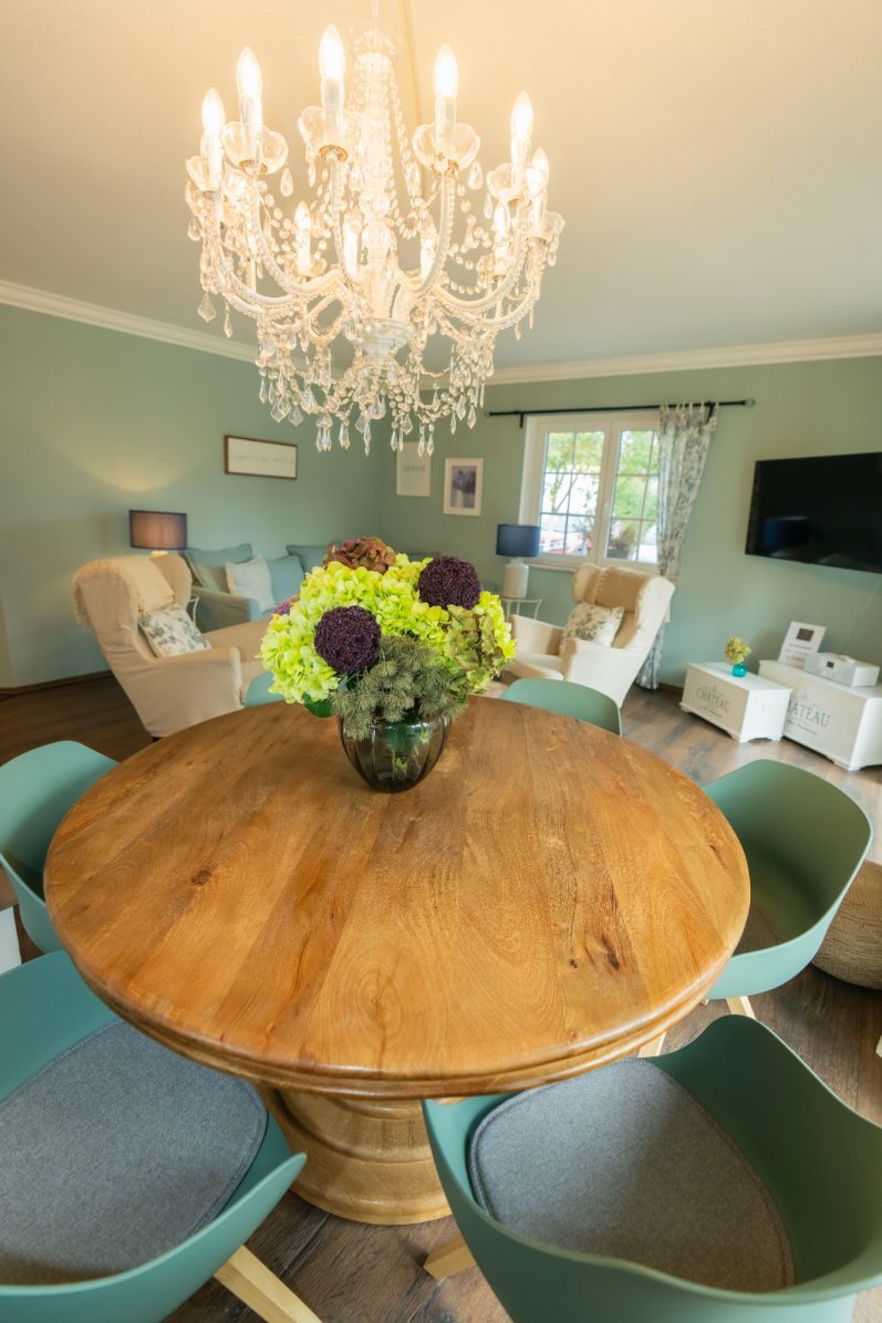 Esstisch mit Blumenstrauß in hellem Wohnbereich